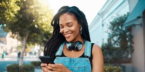 phone, social media and music with a woman in the city using her mobile for streaming, audio or communication web, internet and networking with a young female reading or typing a text message
