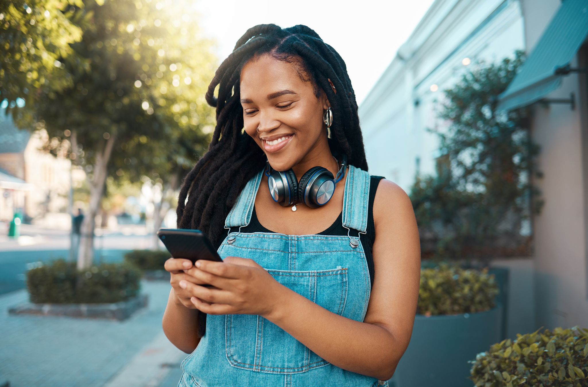 phone, social media and music with a woman in the city using her mobile for streaming, audio or communication web, internet and networking with a young female reading or typing a text message