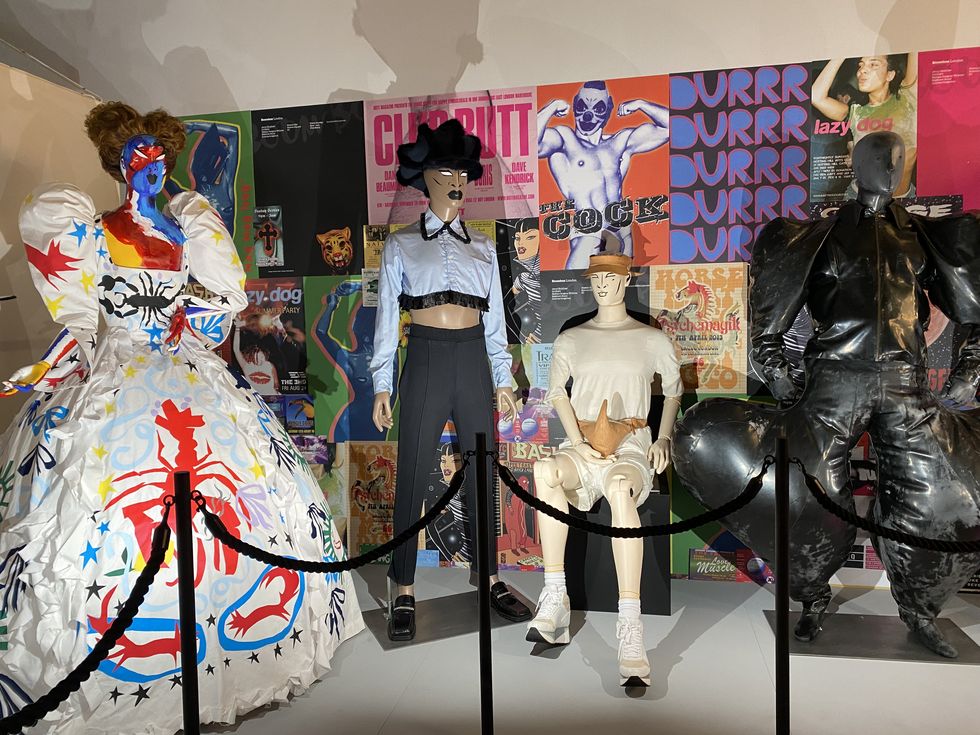 a group of mannequins in a room with posters