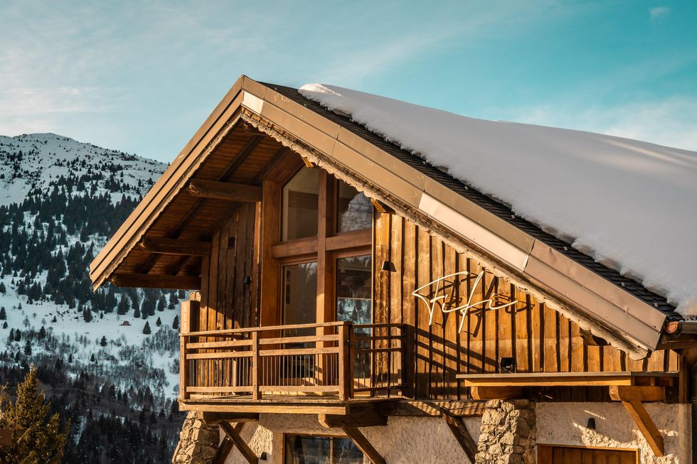 a wooden house with a mountain in the background