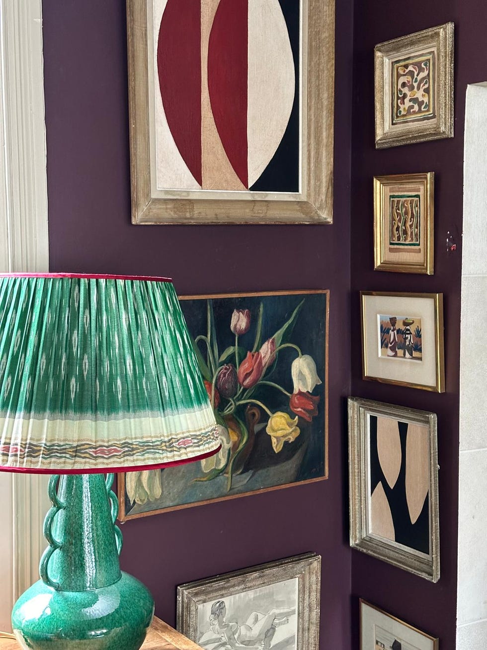 decorative corner with framed artworks and a unique lamp