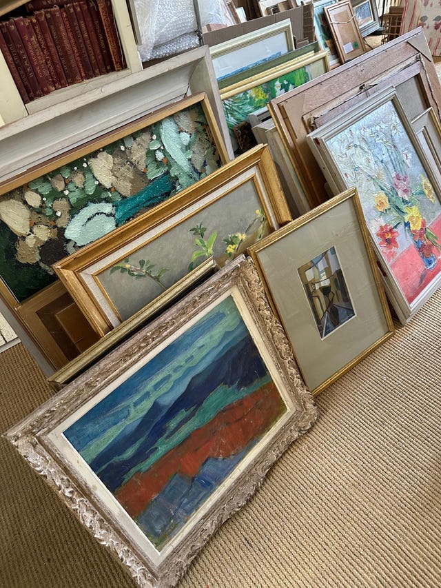 collection of framed artworks displayed in a storage area