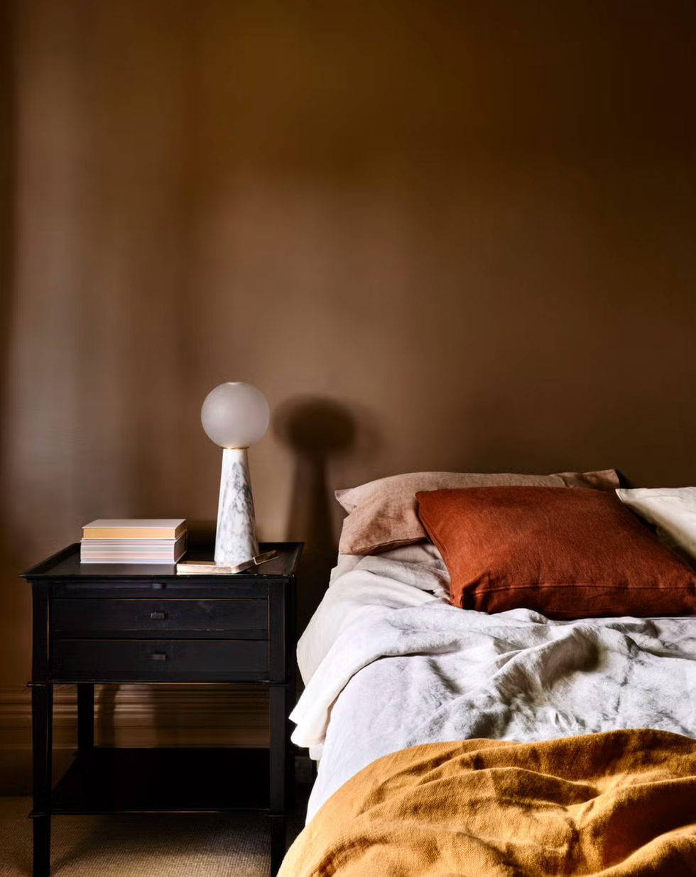 a cozy bedroom scene featuring a neatly made bed and a nightstand