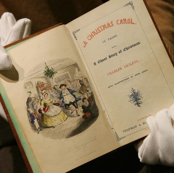 'A Christmas Carol' by Charles Dickens a vintage book titled a christmas carol held in gloved hands featuring an illustration on the left page