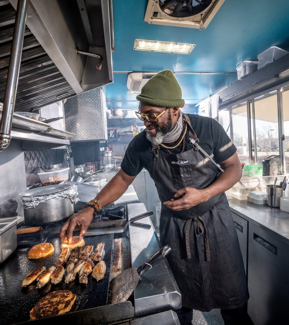 chef marc bynum prepares food in his hush food truck in farmingdale, new york