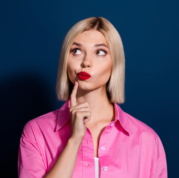 Photo of confused clever woman with bob hairstyle dressed pink shirt look at proposition empty space isolated on dark blue background confused clever woman with bob hairstyle