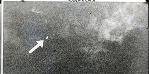 arrow points to ufo in grainy sky photo