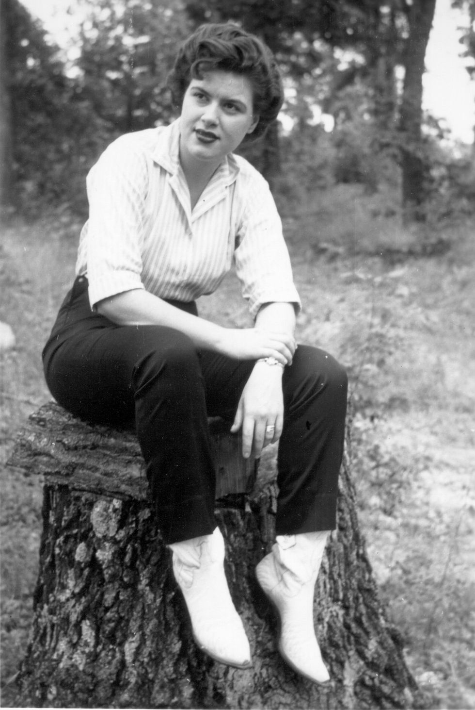 patsy cline sitting on a tree stump and looking right out of frame