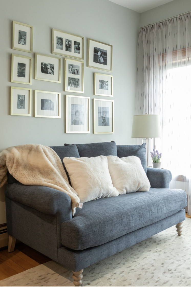 family photo wall ideas, black and white photos with gold frames above the couch