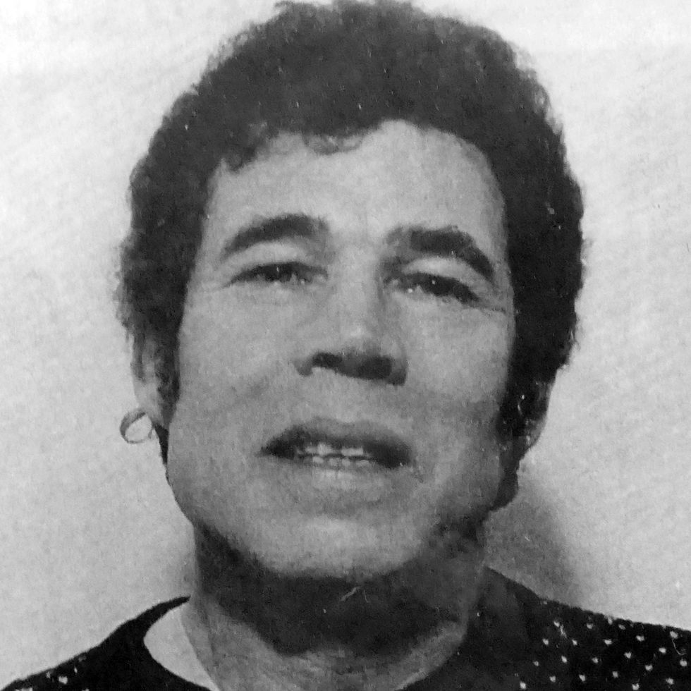 a mug shot of a man with curly hair staring at the camera