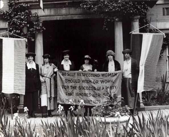 six suffragists at the 1920 republican national convention in chicago gathered in front of a building with suffrage banners