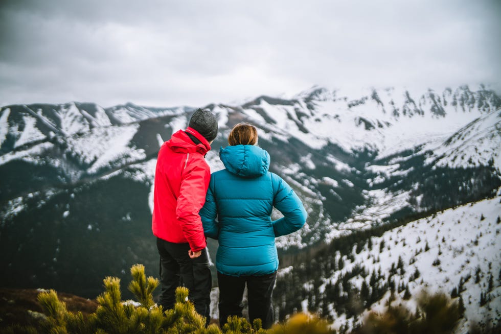 photographer shares ideas with woman on mountain in winter