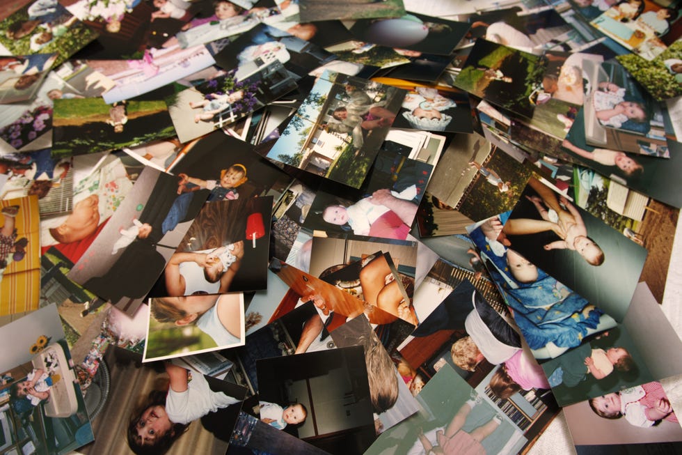 precious, nostalgic memories captured and displayed in a chaotic pile of random, unsorted printed pictures of a cute little girl through various stages of her life, beginning as an infant, up until she is about four years old. a scrapbookers nightmare, or treasure chest!