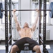 physical athlete doing bench presses