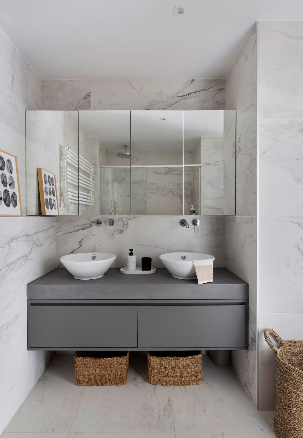 mueble de lavabo volado con dos lavamanos y revestimientos de mármol