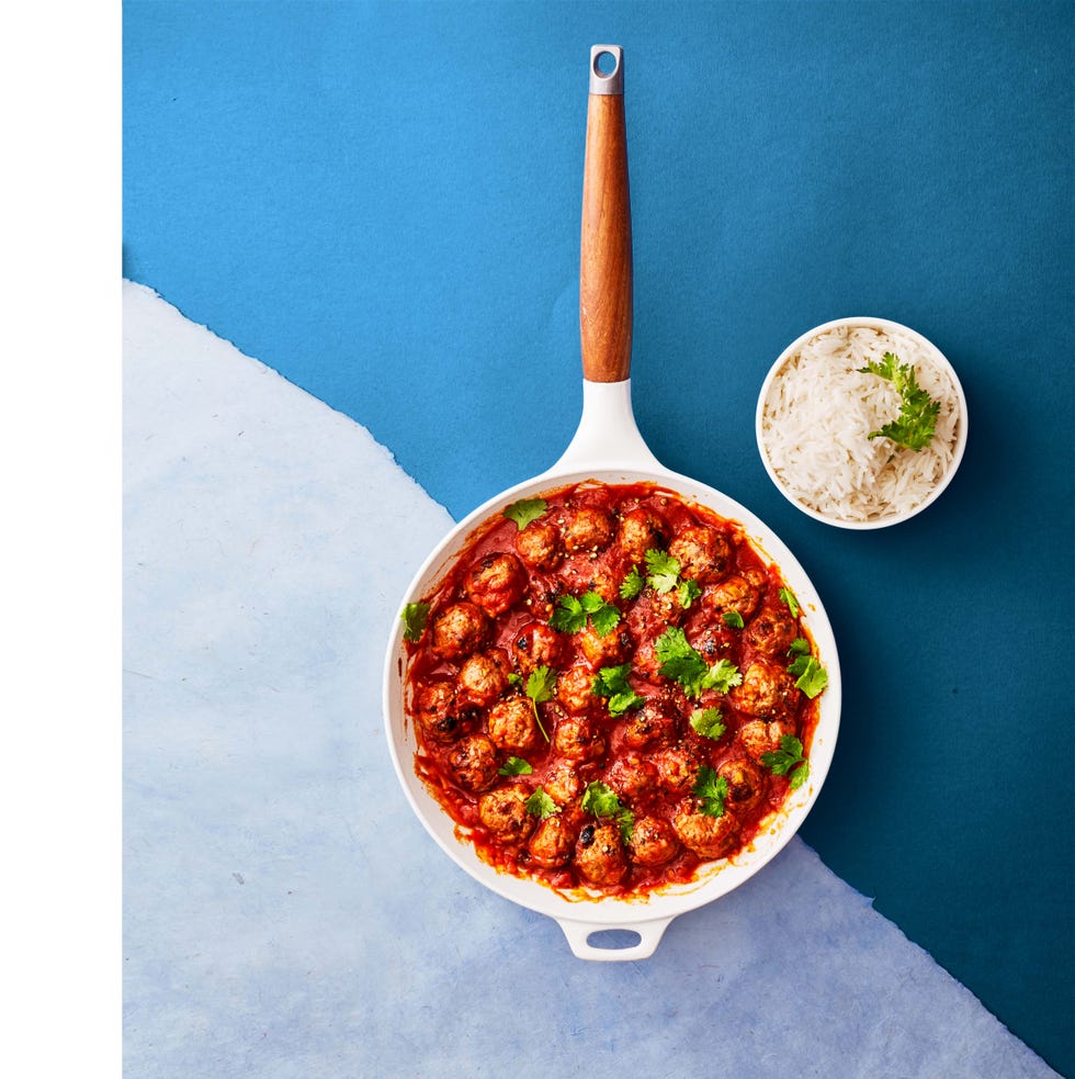 meatballs coated in red sauce in a white pan