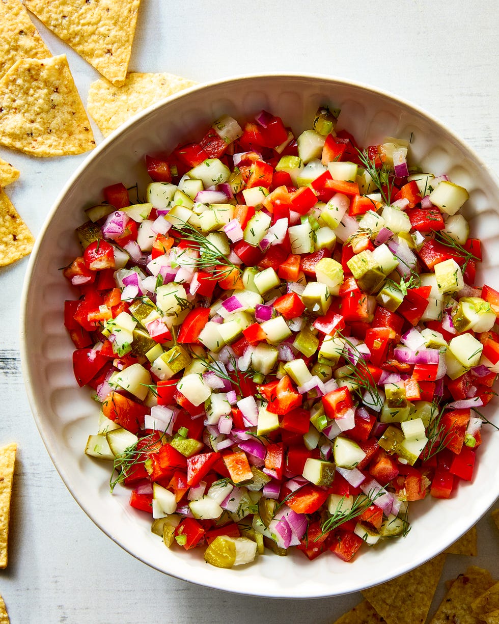 chopped pickles, tomatoes, and onions in a bowl with tortilla chips
