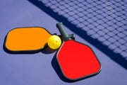 two paddles and a ball in net shadow