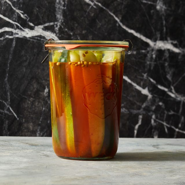 pickles with a kick in a jar on black marble background pickles with a kick in a jar on black marble background