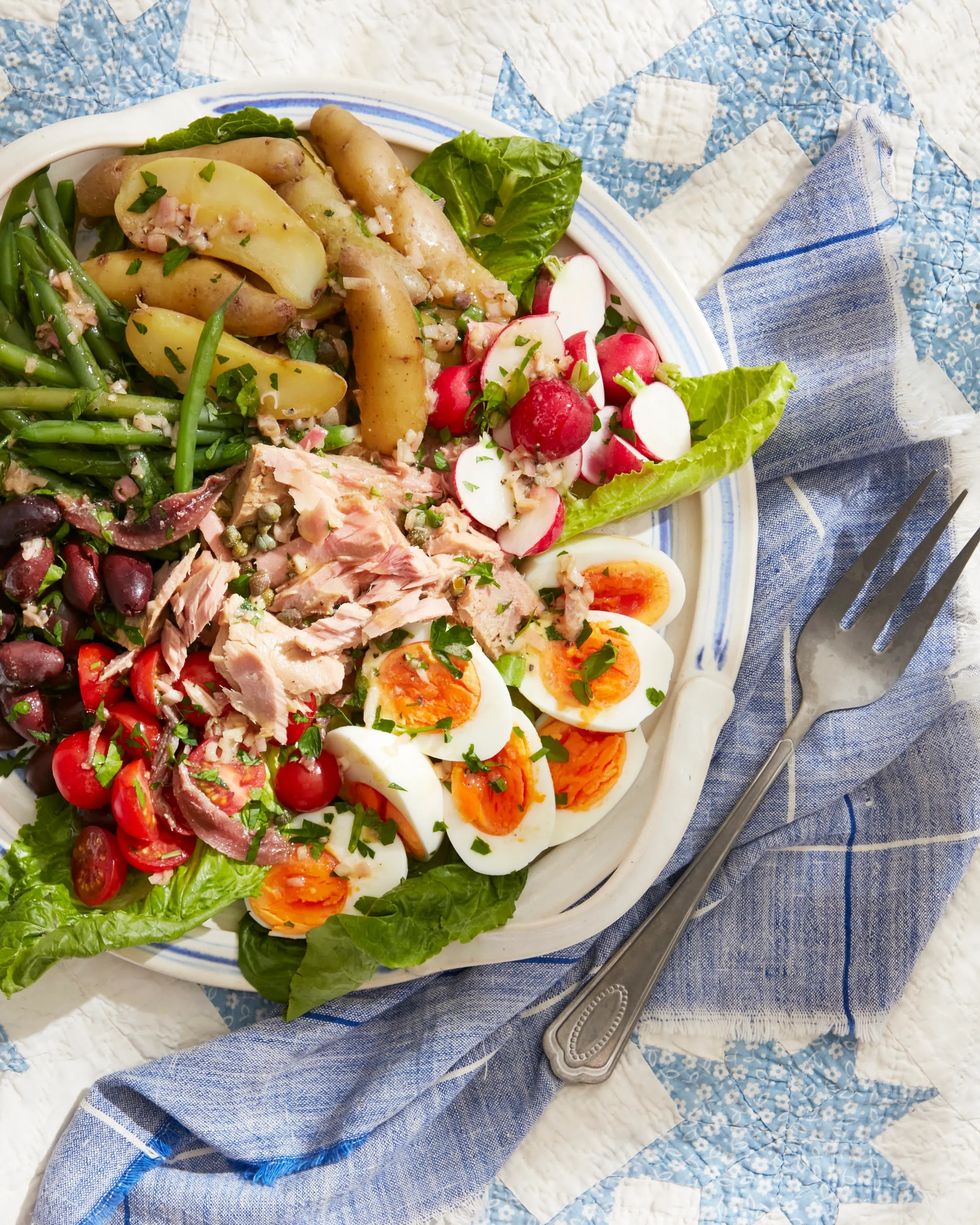 salade niçoise on a plate on a picnic blanket