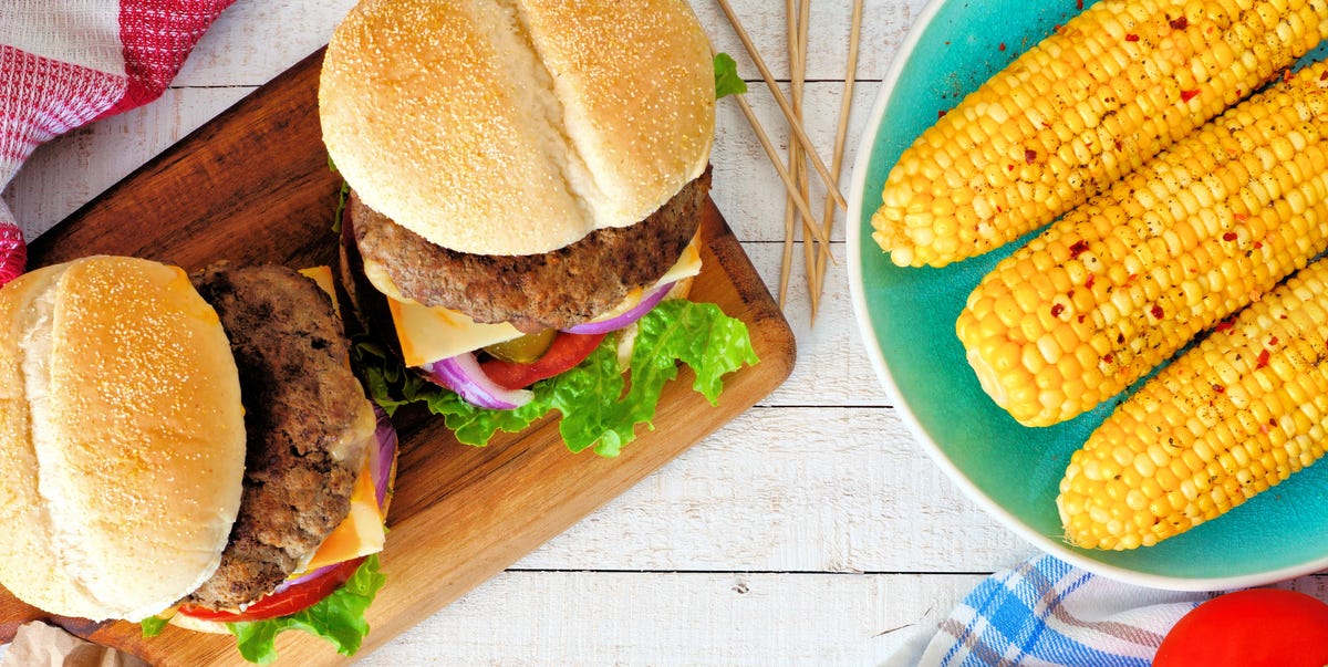 Picnic scene with hamburgers, corn and potato wedges Picnic scene with hamburgers, corn and potato wedges