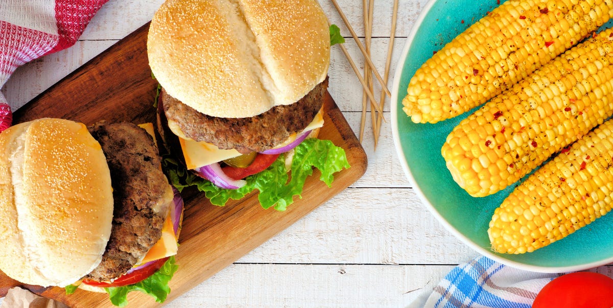 Picnic scene with hamburgers, corn and potato wedges