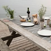 dinner set on wooden picnic table next to lake