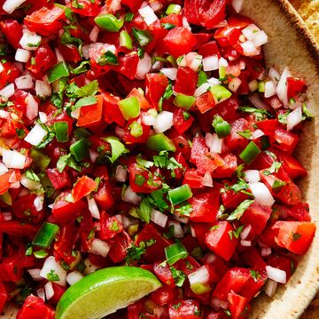 tomatoes, onion, peppers, and fresh cilantro mixed in a bowl with lime to make pico de gallo