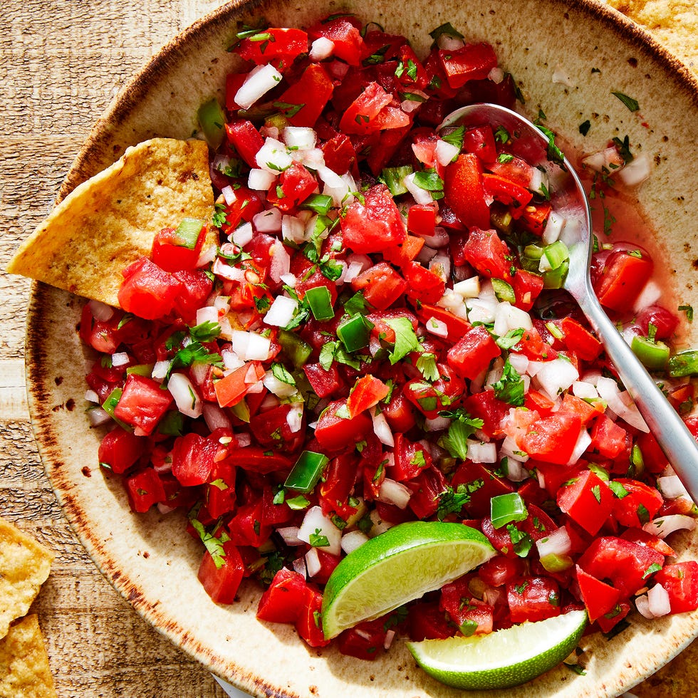 tomatoes, onion, peppers, and fresh cilantro mixed in a bowl with lime to make pico de gallo