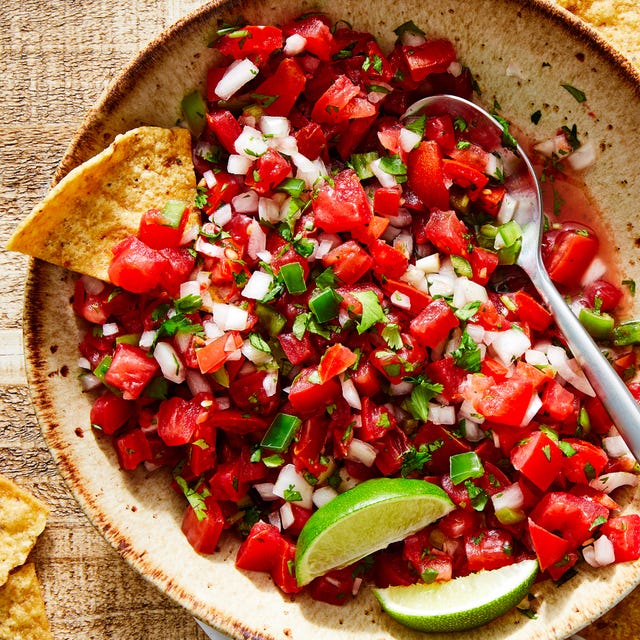 tomatoes, onion, peppers, and fresh cilantro mixed in a bowl with lime to make pico de gallo