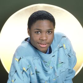 teenage boy smiling while sitting in front of a lit background
