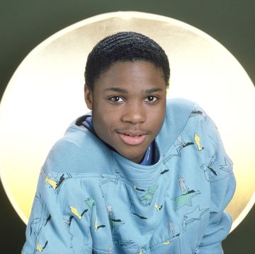 teenage boy smiling while sitting in front of a lit background