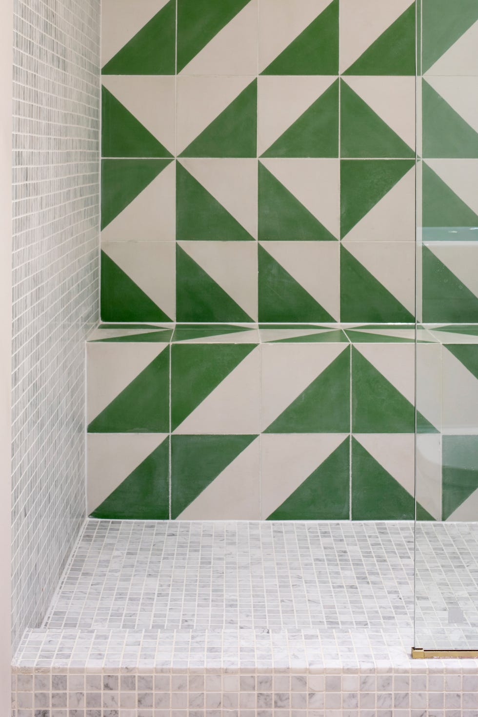 Ducha recubierta de azulejos geométricos en color verde