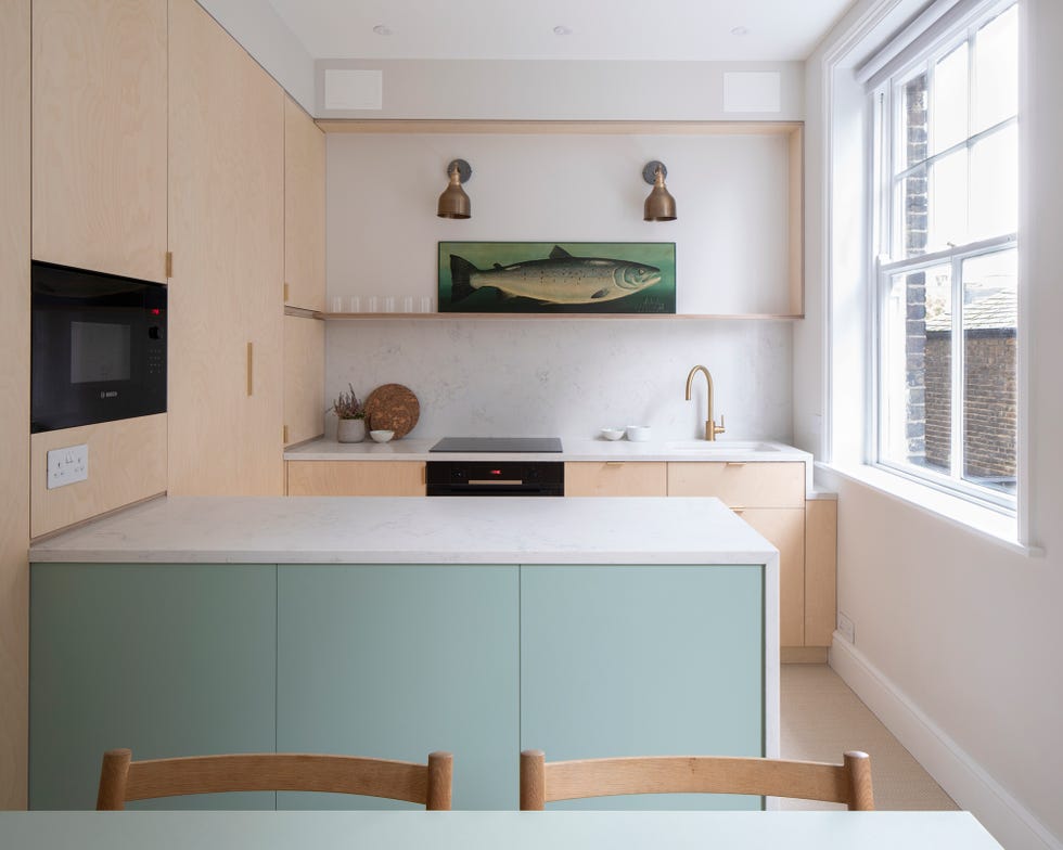 Cocina con armarios de madera contrachapada y península en verde pastel con encimera de mármol
