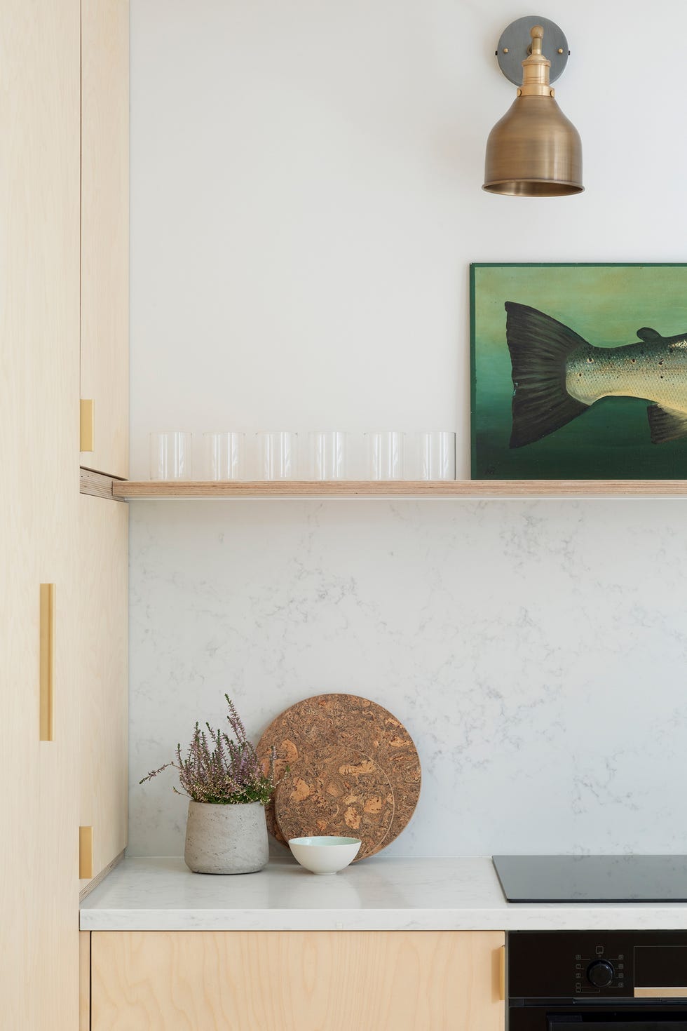 Cocina con encimera y frente de mármol, y apliques de latón