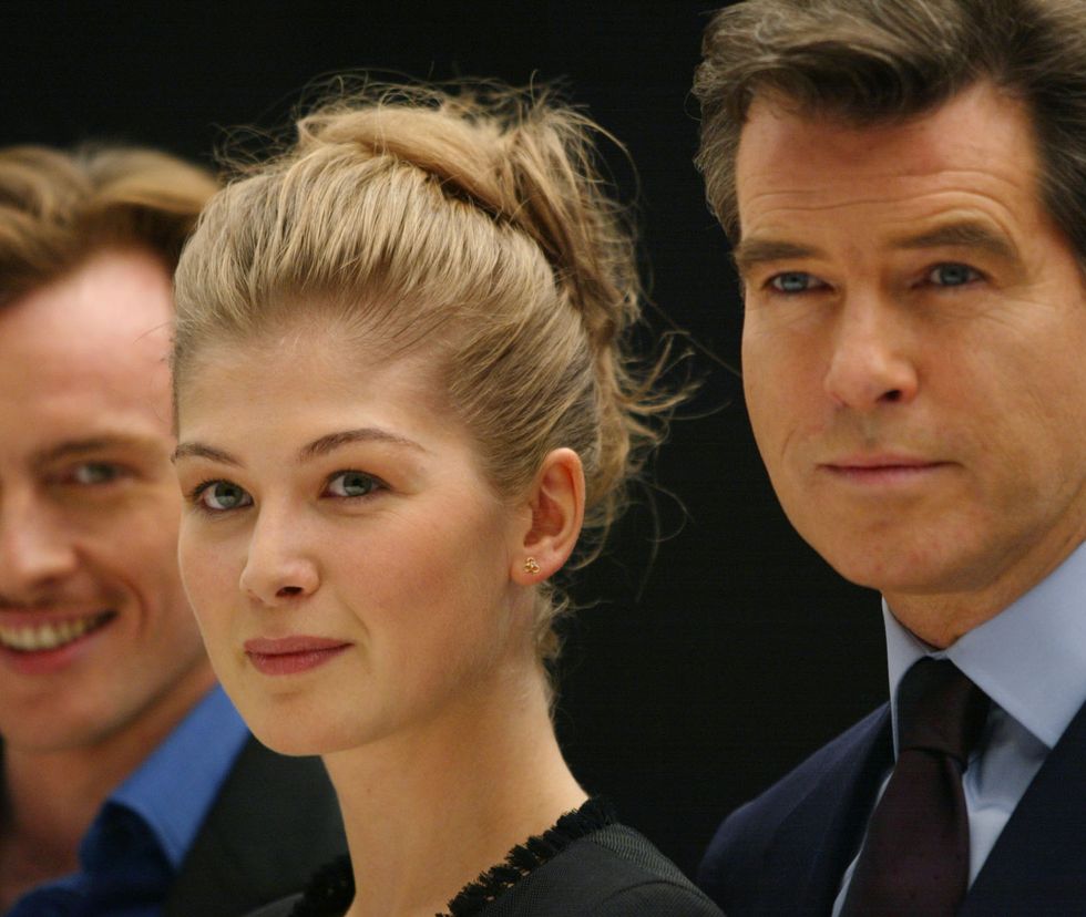 Pierce Brosnan (R) poses with Rosamund Pike (C) an