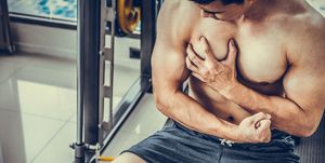 muscular man touching his chest in fitness center bodybuilding concept