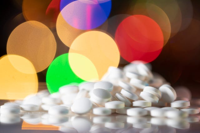 pile of pills colourful lights in the background
