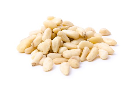 Pile of white pine nuts on a white background