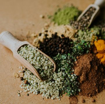 piles of herbs, spices and seasonings on a wooden surface, with scoops, herbs for weight loss
