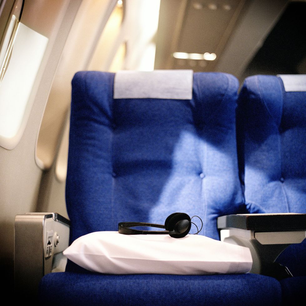 pillow and headphones on seat in airliner