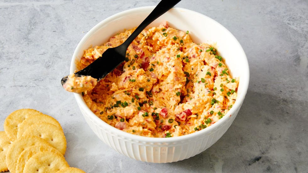 shredded cheese and diced peppers spread in a bowl topped with chives