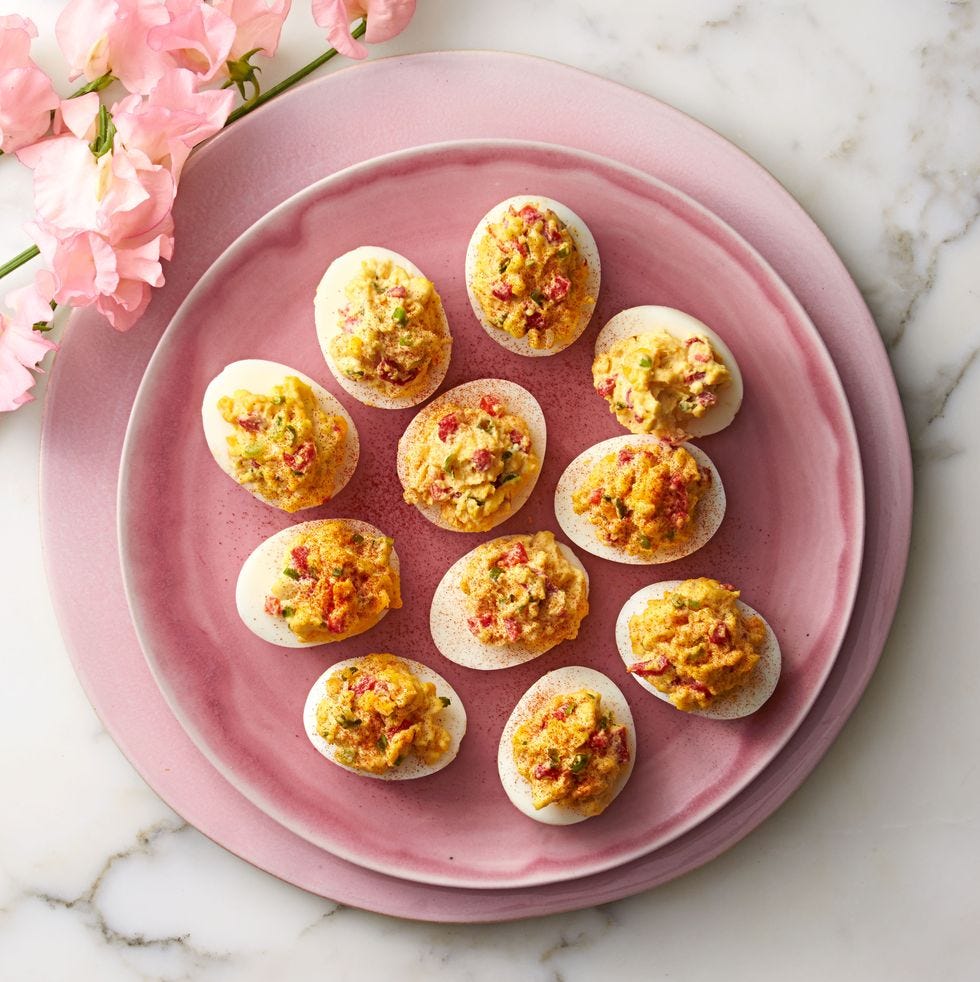 pimiento deviled eggs served on a pink plate