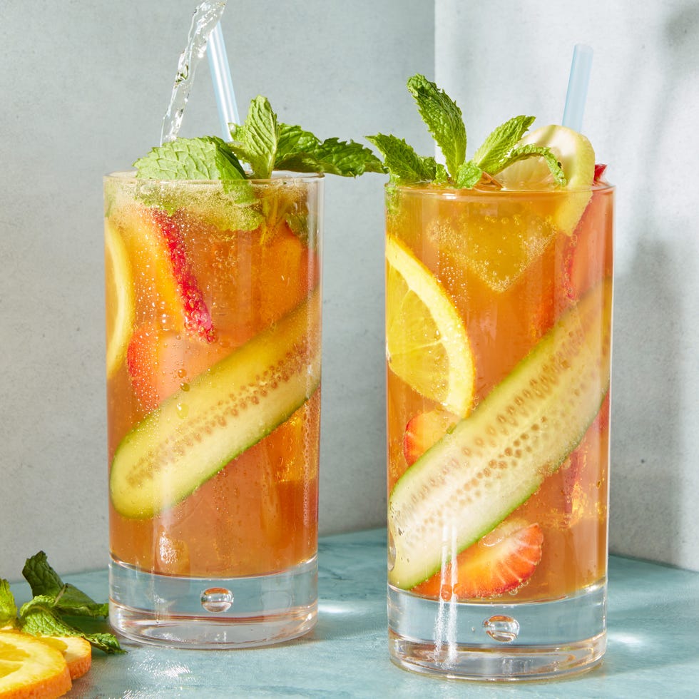 pimms cocktail with cucumber, orange, lemon and strawberry slices garnished with mint and topped with ginger ale