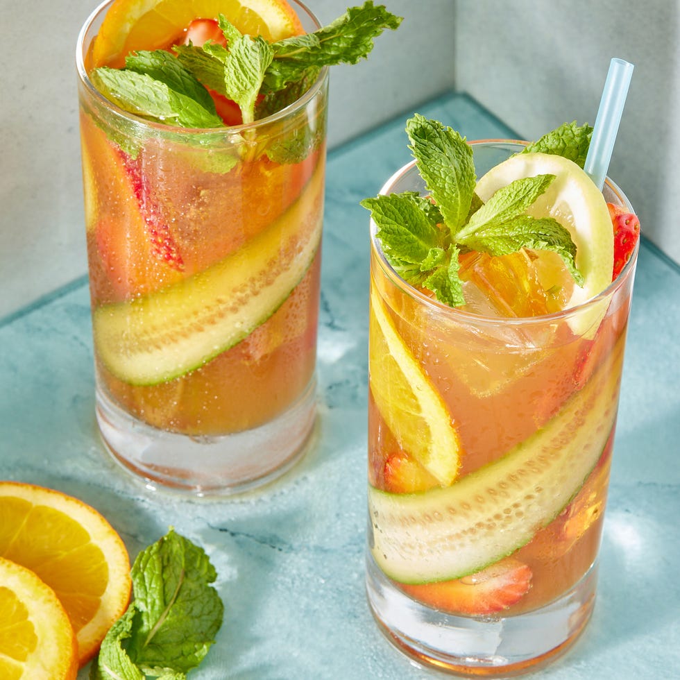 two refreshing cocktails garnished with mint and citrus fruits
