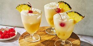 pina colada spritz topped with a maraschino cherry and a pineapple wedge