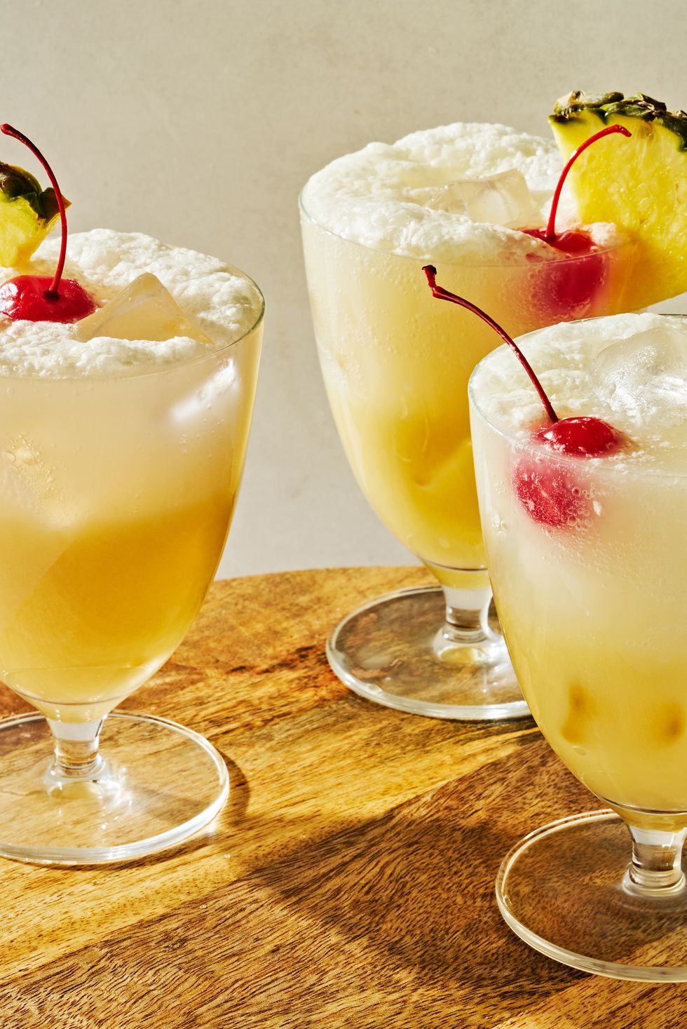 pina colada spritz topped with a maraschino cherry and a pineapple wedge