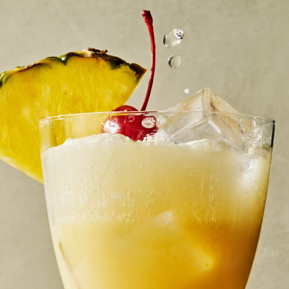 pina colada spritz topped with a maraschino cherry and a pineapple wedge