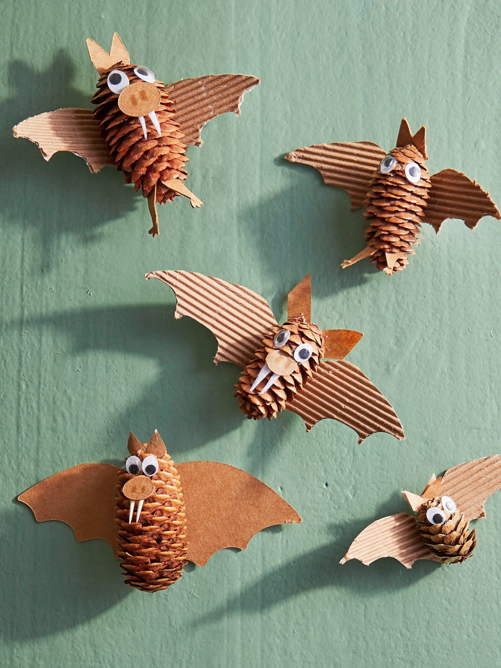 crafted bats made from pine cones and cardboard with googley eyes