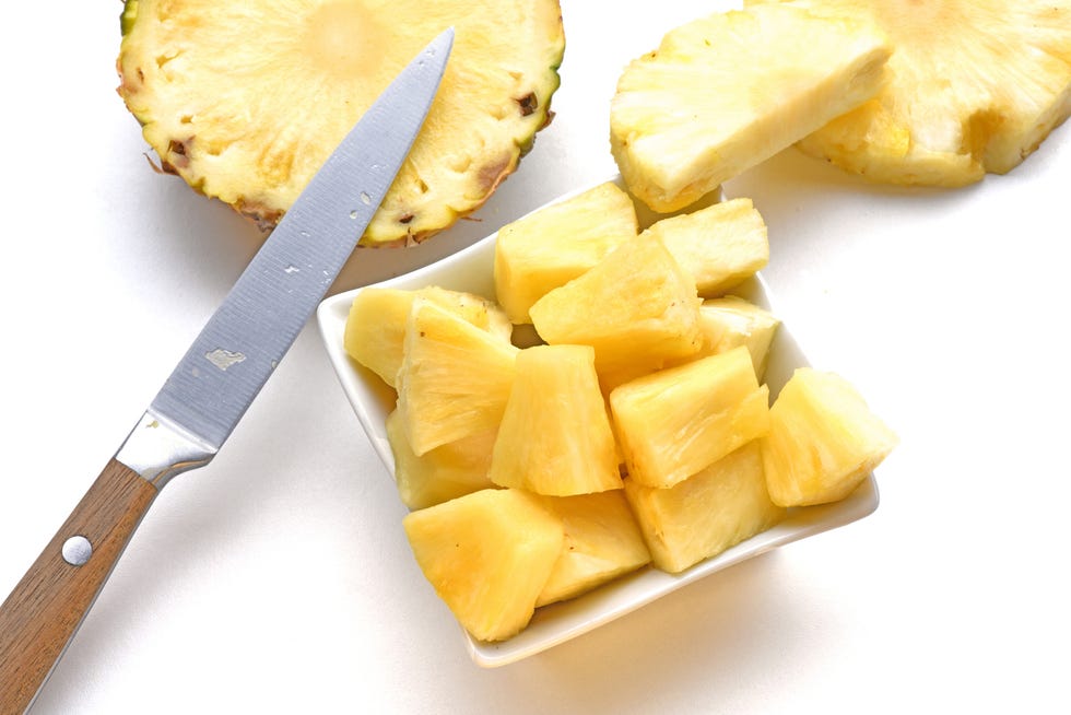 pineapple ananas da ananas comosus,close up of kiwi slices on cutting board over white background